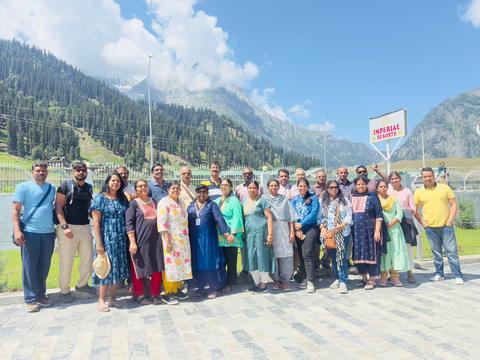 A Coral Yatra Amarnath group in Kashmir, with mountains behind