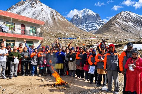 A Coral Yatra group around a fire, with Mount Kailash behind